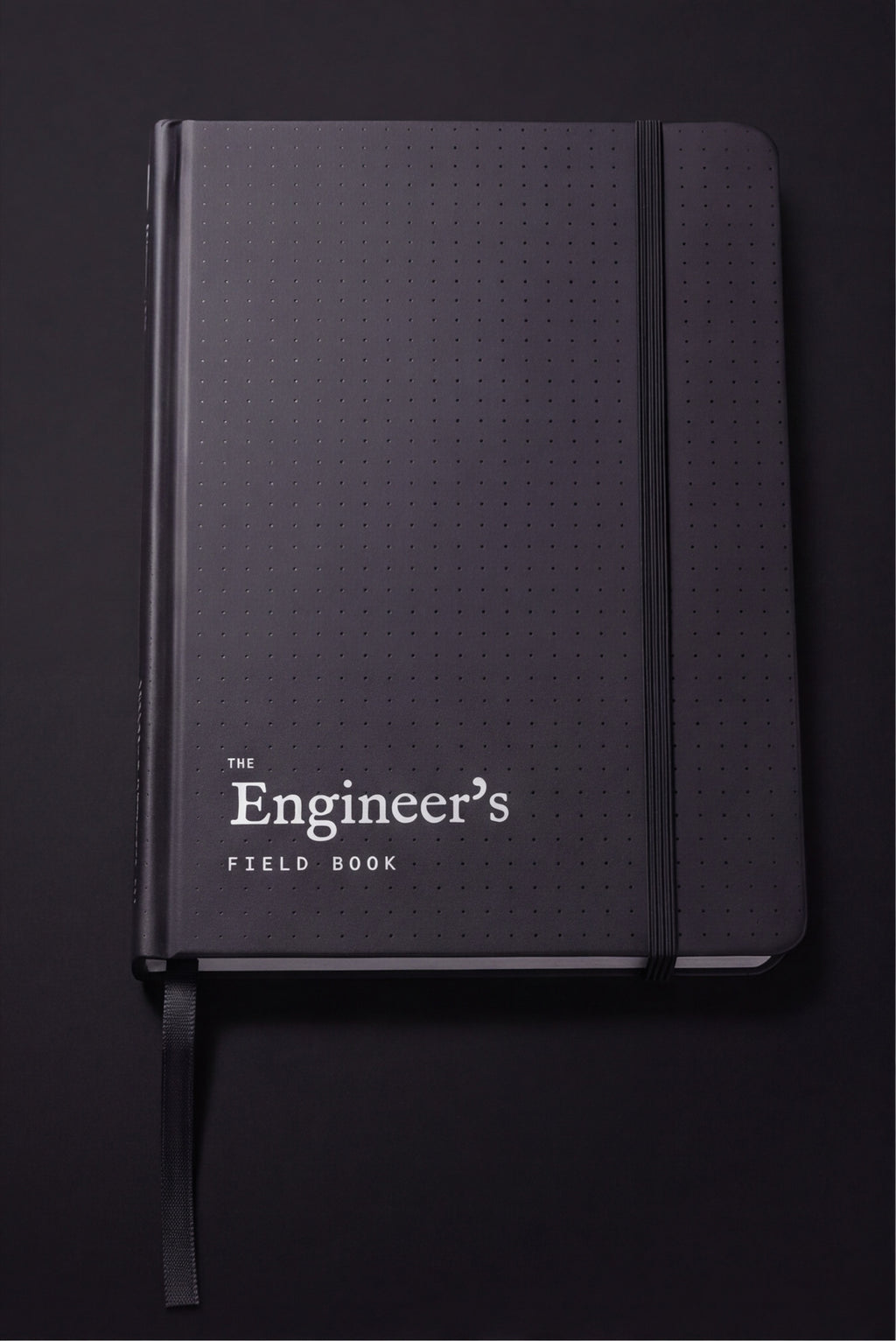 The Engineer's Field Book closed, matte black dot-textured hardcover with elastic closure and ribbon marker