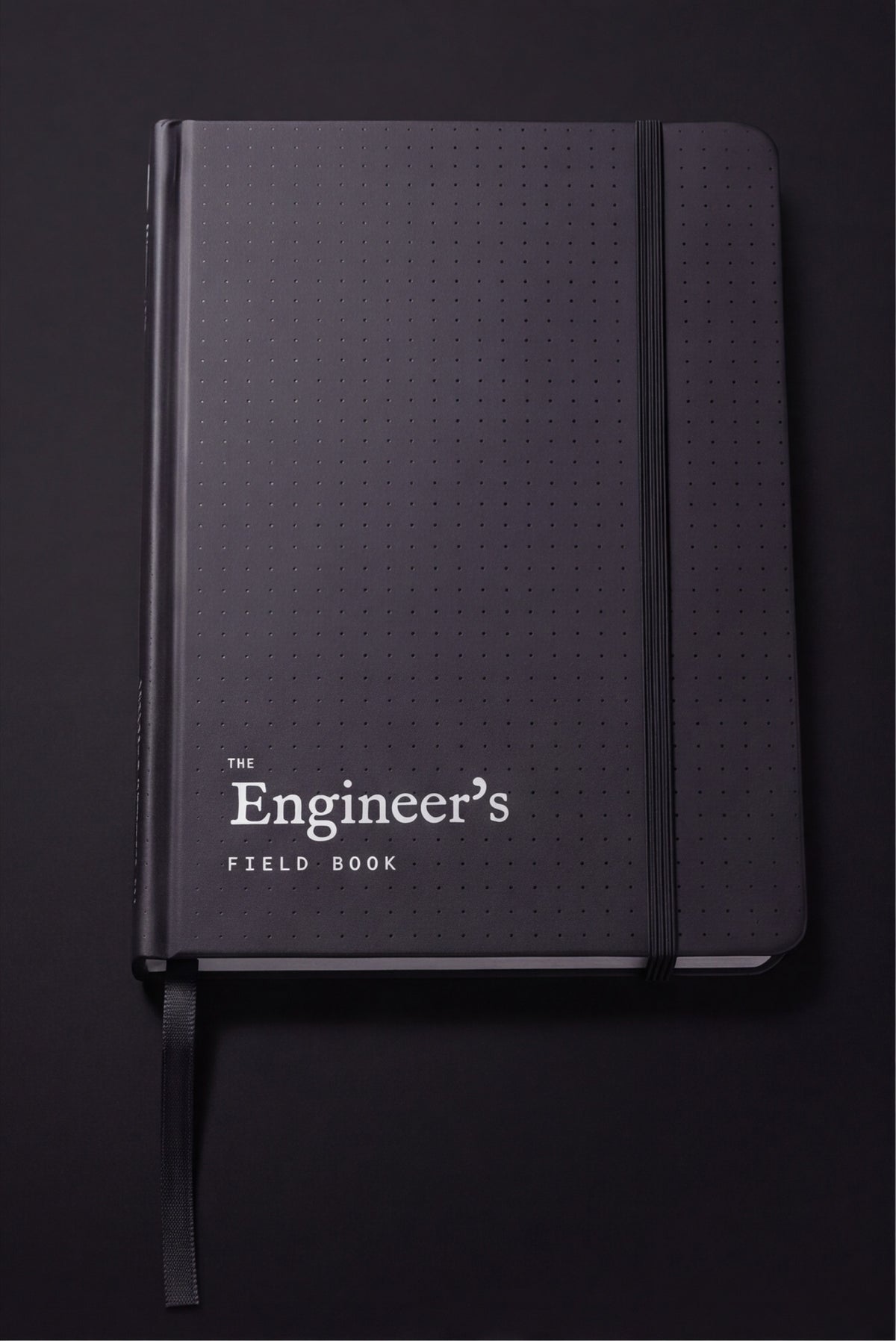 The Engineer's Field Book closed, matte black dot-textured hardcover with elastic closure and ribbon marker